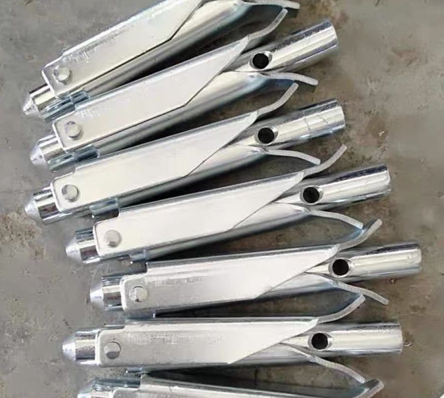 Stacked folding duckbill earth anchors for compact warehouse storage and low-cost shipping.